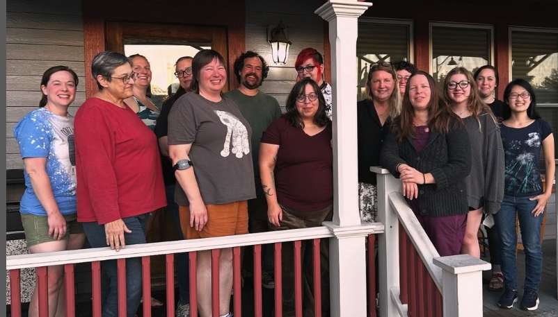 The staff, the heart and soul of our Sow's Ear Knitting and Crafting Community, standing on the porch in front of the cafe, all wearing big smiles for the camera.